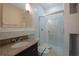 Bathroom with granite counter, custom cabinetry, glass shower doors and tiled walls at 572 Vinings Estates Se Dr # B9, Mableton, GA 30126