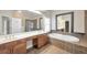 Spacious bathroom with dual sinks, soaking tub, tile floors, and large mirrors at 572 Vinings Estates Se Dr # B9, Mableton, GA 30126