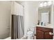 Cozy bathroom with a white shower curtain, wooden vanity, and ample lighting for a refreshing experience at 2820 Garonne Way, Cumming, GA 30041