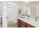 Clean bathroom featuring a wooden vanity, white countertop, framed mirror, and shower with curtain at 2820 Garonne Way, Cumming, GA 30041