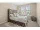 Cozy bedroom featuring a tufted headboard, soft carpeting, and bright window for natural light at 2820 Garonne Way, Cumming, GA 30041