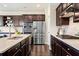 Open kitchen features stainless steel appliances and dark wood cabinets at 2820 Garonne Way, Cumming, GA 30041