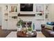 Living room with a brick fireplace, built-in shelving, dark hardwood floors and a decorative coffee table at 2820 Garonne Way, Cumming, GA 30041