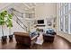 Spacious living room with dark hardwood floors, a fireplace, built-in shelving, and a staircase to the second floor at 2820 Garonne Way, Cumming, GA 30041