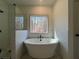 A luxurious soaking tub sits in front of a bright window with a separate shower at 34 Harmony Ridge Dr, Temple, GA 30179