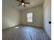 An empty bedroom with neutral walls, ceiling fan, and a window with natural light at 34 Harmony Ridge Dr, Temple, GA 30179