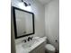 Charming powder room with a white vanity, marble countertop, black faucet, and modern light fixture at 34 Harmony Ridge Dr, Temple, GA 30179