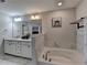 Inviting bathroom with white cabinets and a soaking tub; great lighting and fixtures add to its appeal at 376 Provenance Dr, Atlanta, GA 30328