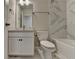 Bright bathroom featuring Carrara marble tile, tub, toilet, and vanity at 376 Provenance Dr, Atlanta, GA 30328