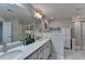 Stylish bathroom featuring dual sinks with a large mirror, shower, and soaking tub; marble floors and light fixtures at 376 Provenance Dr, Atlanta, GA 30328
