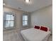 Bright and airy bedroom with two windows, soft gray carpet, and red pillows on a low bed at 376 Provenance Dr, Atlanta, GA 30328