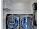 Modern laundry room with Samsung washer and dryer, plus a vacuum cleaner and shelving for organizing at 376 Provenance Dr, Atlanta, GA 30328