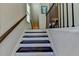 Bright staircase with dark wood steps, white risers, and decorative railings at 376 Provenance Dr, Atlanta, GA 30328