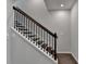 A staircase with hardwood steps and a white railing with dark metal balusters, leading to the upper floor at 376 Provenance Dr, Atlanta, GA 30328