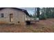 An exterior view of the back of the house shows an aging brick house with a small deck at 868 Maxey Hill Ct, Stone Mountain, GA 30083