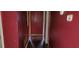 Narrow hallway with red walls and dark wood flooring; an ideal connector between spaces at 868 Maxey Hill Ct, Stone Mountain, GA 30083
