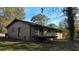 Back view of brick home with deck, yard and mature trees at 868 Maxey Hill Ct, Stone Mountain, GA 30083