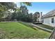 A spacious backyard with a large grassy area, mature trees, and a fenced pool area, ideal for outdoor activities at 9435 Grande Dr, Winston, GA 30187