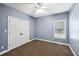 A bedroom features blue walls, carpet flooring, a window and a ceiling fan at 9435 Grande Dr, Winston, GA 30187