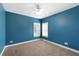 Bright bedroom features two double-hung windows, light brown carpet, and dark blue walls at 9435 Grande Dr, Winston, GA 30187