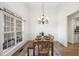 Cozy dining room with a large window, wooden table and chairs, and modern chandelier at 9435 Grande Dr, Winston, GA 30187
