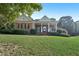 Attractive brick home featuring a symmetrical design, columned porch, and lush landscaping at 9435 Grande Dr, Winston, GA 30187