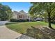 Inviting brick home with a columned front porch, well-manicured lawn, and mature trees at 9435 Grande Dr, Winston, GA 30187