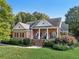 Charming red brick home featuring a covered front porch, manicured landscaping, and a welcoming entrance at 9435 Grande Dr, Winston, GA 30187