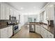 Bright kitchen with white cabinets, stainless appliances, and light wood flooring at 9435 Grande Dr, Winston, GA 30187