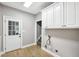 A laundry room features white cabinets and wooden flooring at 9435 Grande Dr, Winston, GA 30187