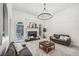 Bright living room with a modern chandelier, fireplace, and plenty of space for entertaining at 9435 Grande Dr, Winston, GA 30187