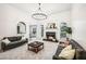 Bright living room showcasing fireplace, modern chandelier and grey sofas at 9435 Grande Dr, Winston, GA 30187