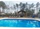 Inviting in-ground pool with lounge chairs, umbrellas, and an outdoor dining area, perfect for relaxation at 9435 Grande Dr, Winston, GA 30187