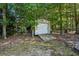 Outdoor shed provides extra storage space surrounded by mature trees at 9435 Grande Dr, Winston, GA 30187