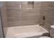 A full tub in a bathroom featuring wood-look tiling and modern fixtures at 1395 Winburn Dr, East Point, GA 30344