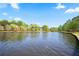 Serene lake view featuring a calm surface reflecting trees and a clear blue sky with clouds at 394 Teal Ct, Roswell, GA 30076