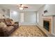 Comfortable living room with brown leather sofa, ceiling fan, and decorative fireplace with mantel at 394 Teal Ct, Roswell, GA 30076