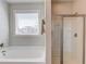 Bright bathroom features a soaking tub, stand up shower and a large window at 4152 Woodward Mill Rd, Sugar Hill, GA 30518