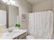 Bathroom featuring white vanity, framed mirror, shower with decorative white shower curtain at 4152 Woodward Mill Rd, Sugar Hill, GA 30518