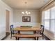 Elegant dining room featuring a wooden table, bench seating, modern chandelier and natural light, perfect for Gathering gatherings at 4152 Woodward Mill Rd, Sugar Hill, GA 30518