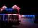 Nighttime view of the home exterior featuring patriotic red, white, and blue holiday lighting at 4152 Woodward Mill Rd, Sugar Hill, GA 30518