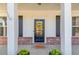 Charming front door with a wreath, flanked by white columns and planters, creating a welcoming entrance at 4152 Woodward Mill Rd, Sugar Hill, GA 30518