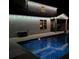 Illuminated backyard pool and patio with outdoor furniture at night at 4152 Woodward Mill Rd, Sugar Hill, GA 30518