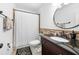 Stylish bathroom featuring a dark vanity with modern fixtures, a round mirror, and neutral tile accents for a contemporary feel at 2325 Woodcrest Se Dr, Smyrna, GA 30082