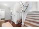 Inviting foyer with hardwood floors, a staircase with white railings, and a bench for a warm and welcoming entrance at 2325 Woodcrest Se Dr, Smyrna, GA 30082