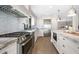 Modern kitchen featuring white cabinetry, herringbone backsplash, stainless steel appliances, and an oversized center island at 2325 Woodcrest Se Dr, Smyrna, GA 30082