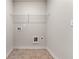 This laundry room has tile floors and a metal rack for storage at 2783 Bayrose Cir # 83, Atlanta, GA 30344