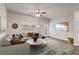 Bright living room with a large sofa, area rug, ceiling fan, and mounted television at 2783 Bayrose Cir # 83, Atlanta, GA 30344
