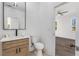 A clean, modern bathroom with a sleek vanity, faucet, and mirror next to a bedroom entryway at 61 Newcastle Sw St, Atlanta, GA 30314