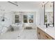 Bright bathroom with white marble accent wall, soaking tub, walk-in shower, double vanity and great natural light at 61 Newcastle Sw St, Atlanta, GA 30314
